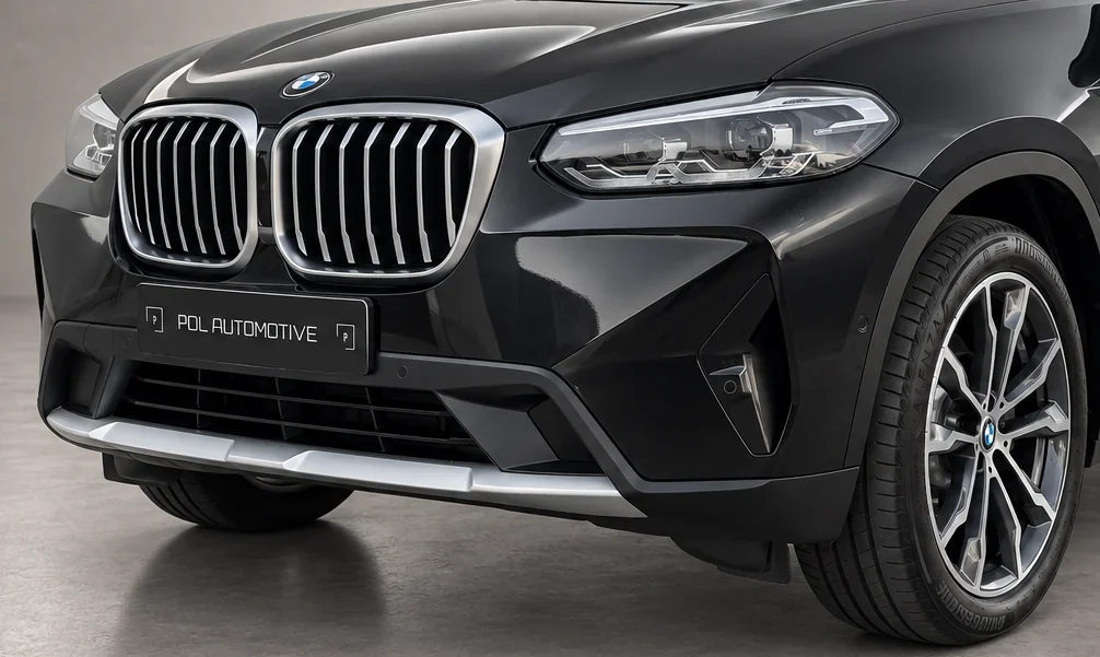 Close-up van de voorkant van een zwarte BMW met grille en koplamp, foto van Pol Automotive